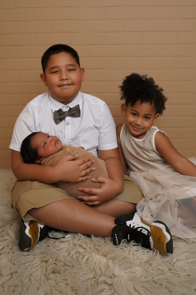 A couple of kids sitting on top of a bed
